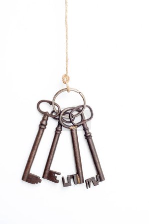 Foto de Un paquete de llaves de metal antiguas cuelgan de una cuerda, mostrando su encanto rústico y diseño vintage. Cada llave, única y envejecida, cuenta una historia de cerraduras largamente olvidadas. - Imagen libre de derechos