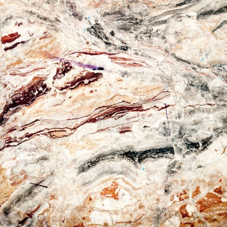 Foto de Primer plano de una superficie de mármol, mostrando una mezcla de ricas venas y remolinos en tonos naturales, acentuados por intrincados patrones y texturas. Ideal para fondos o elementos de diseño de lujo. - Imagen libre de derechos