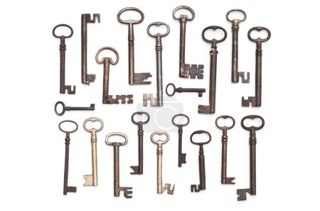 Téléchargez les photos : Une collection de clés antiques sur fond blanc. Les clés sont de différentes tailles et styles, tous avec un aspect rustique usé. - en image libre de droit