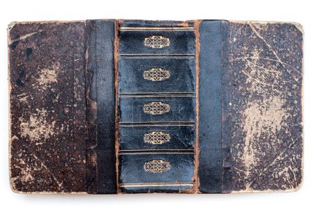 Foto de Primer plano de una cubierta de libro antiguo que muestra un diseño moteado textura única, con una columna vertebral gastada que revela su edad e historia. - Imagen libre de derechos