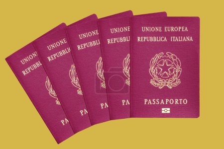 Foto de Pasaportes biométricos italianos de la Unión Europea aislados sobre fondo amarillo - Imagen libre de derechos