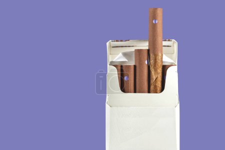 Foto de Paquete de diez cigarros pequeños aislados en el espacio de copia de fondo púrpura - Imagen libre de derechos