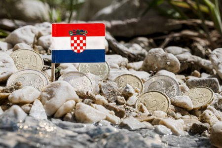 Foto de Bandera de Croacia con monedas en euros en medio de la superficie de grava en la orilla del río, cambio de divisas, finanzas empresariales y concepto de economía, macro primer plano - Imagen libre de derechos
