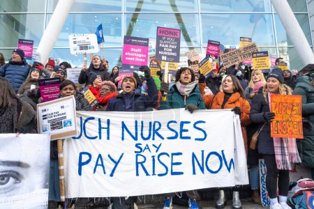 Foto de London, UK. 18th January 2023. Striking nurses with placards and banners, demonstrating outside the main entrance of University College Hospital, London, in protest to government cuts and unfair pay. - Imagen libre de derechos