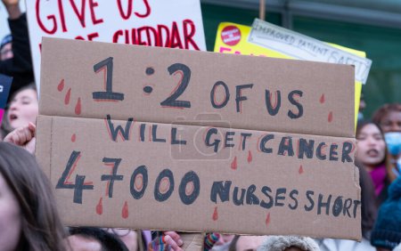 Téléchargez les photos : London, UK. 18th January 2023. Signs and posters waved by striking nurses, demonstrating outside the main entrance of University College Hospital, London, in protest to government cuts and unfair pay. - en image libre de droit