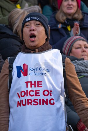 Téléchargez les photos : London, UK. 18th January 2023. Striking nurses holding placards and signs, demonstrating outside the main entrance of University College Hospital, London, in protest to government cuts and unfair pay. - en image libre de droit