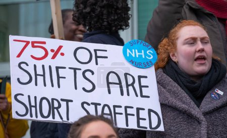 Photo for London, UK. 18th January 2023. Striking nurses holding placards and signs, demonstrating outside the main entrance of University College Hospital, London, in protest to government cuts and unfair pay. - Royalty Free Image