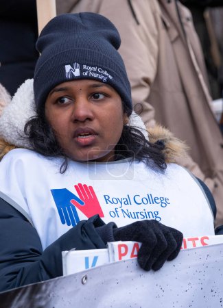 Foto de Striking nurses with placards and banners, demonstrating outside the main entrance of University College Hospital, London, in protest to government cuts and unfair pay. - Imagen libre de derechos