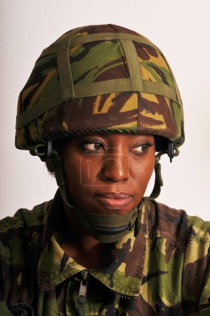 Portrait of black female soldier wearing British Army green camouflage uniform.