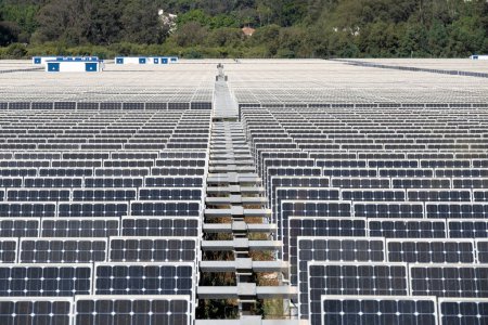 Weitwinkelblick auf Reihen umweltfreundlicher Photovoltaik-Module, die das Sonnenlicht nutzbar machen, auf einem ländlichen Solarpark in Spanien.