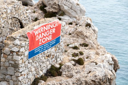 Photo for Large banner on the side of an old building along the Gibraltar coastline, waring the public to stay away due to ongoing demolition. - Royalty Free Image