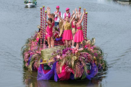 Téléchargez les photos : SCHIPLUIDEN, PAYS-BAS - 23 JUIN 2023 : Défilé annuel coloré de bateaux décorés de fleurs et de légumes avec des gens joyeux habillés chantant et dansant. Parade appelée Varend Corso. - en image libre de droit