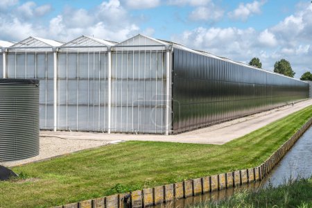 Téléchargez les photos : Perspective view of a modern industrial greenhouse with solar and rainwater harvesting systems in Westland, the Netherlands. Westland est une région des Pays-Bas. - en image libre de droit