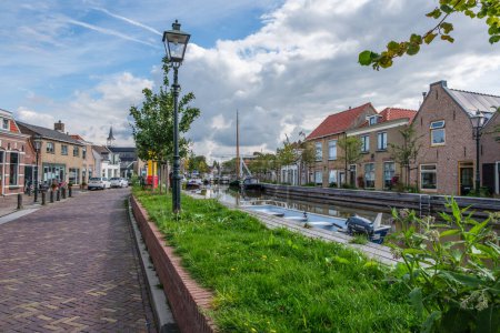 Téléchargez les photos : SCHIPLUIDEN, PAYS-BAS - 29 AOÛT 2023 : Vue sur le magnifique centre du village de Schipluiden avec ses maisons pittoresques et ses bateaux dans le canal, village proche de La Haye aux Pays-Bas - en image libre de droit