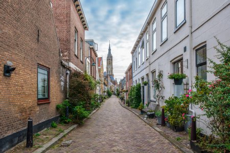 Téléchargez les photos : Paysage urbain pittoresque de Delft avec vue à travers une ruelle ancienne étroite sur la tour du célèbre Nieuwe Kerk. Delft, Pays-Bas. Ancienne ruelle appelée The Trompet Straat - en image libre de droit