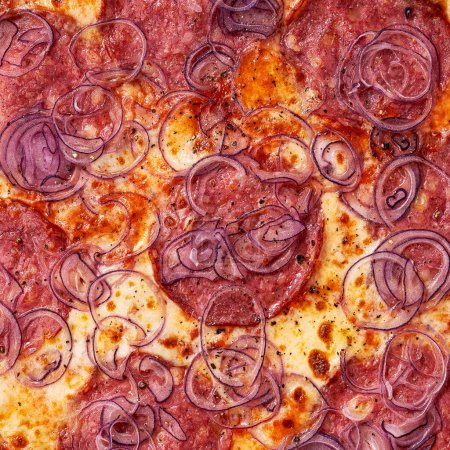 Foto de Primer plano de relleno y textura de pizza, cebollas rojas, salami y queso en la parte superior - Imagen libre de derechos