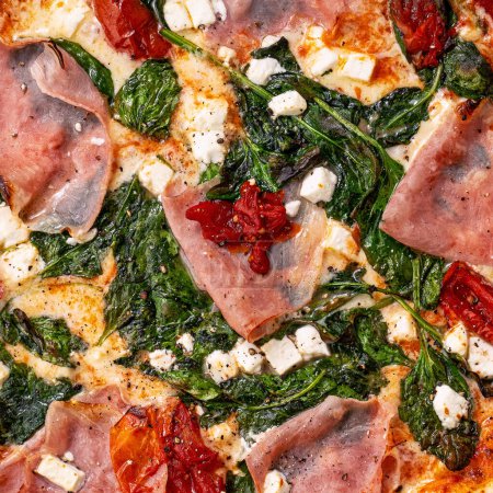 Foto de Primer plano de relleno y textura de pizza, jamón, espinacas y queso feta en la parte superior - Imagen libre de derechos