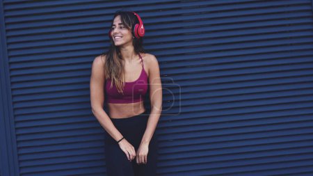 Foto de Retrato de una joven feliz y hermosa mujer relajándose escuchando música con auriculares en la ciudad. Concepto de estilo de vida de la juventud, diversión, disfrutar de la vida. - Imagen libre de derechos