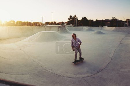 Foto de Skateboarder retrato deslizándose en el parque de skate. Luz del atardecer, estilo de vida. - Imagen libre de derechos
