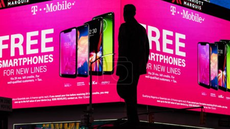 Téléchargez les photos : NEW YORK - FÉVRIER 2020 : Vue de Times Square la nuit avec la silhouette de la statue de George M. Cohan. TS est une intersection touristique animée de publicités de commerce et une rue célèbre de NYC. - en image libre de droit