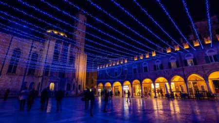 Photo for People walking in People's square at night with Christmas decoration. Ascoli Piceno, Italy. - Royalty Free Image