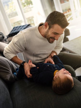 Téléchargez les photos : Père et son fils s'amusent sur le canapé à la maison. Style de vie. - en image libre de droit