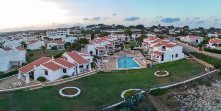 Téléchargez les photos : MENORCA, ESPAGNE - JUILLET 2019 : Vue aérienne du village résidentiel avec piscine. - en image libre de droit