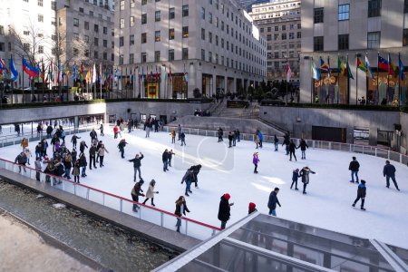 Photo for NEW YORK - FEBRUARY, 2020: Ice skating in Rockefeller Center plaza on 5th Avenue. It was built by the Rockefeller family in 1939 and was declared a National Historic Landmark in 1987. - Royalty Free Image