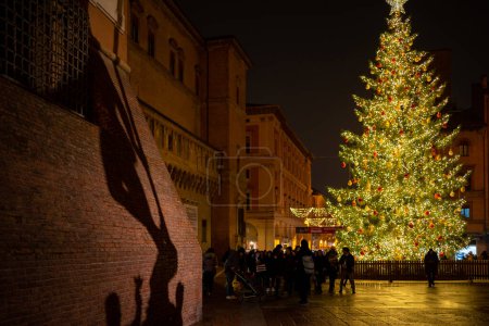 Foto de BOLOGNA, ITALIA - DICIEMBRE 2019: Nettuno sombra fuente y pino decorado árbol de Navidad por la noche. - Imagen libre de derechos