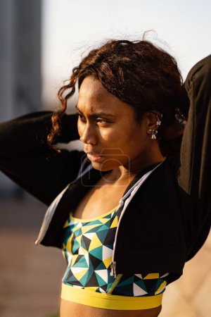 Foto de Confiado joven negro africano deportivo mujer de cerca retrato al aire libre en un día soleado. - Imagen libre de derechos