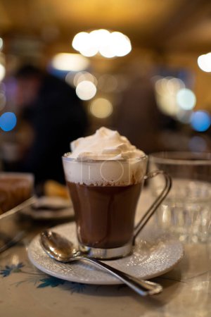 Foto de Copa de chocolate caliente con crema en la parte superior dentro de la cafetería. - Imagen libre de derechos