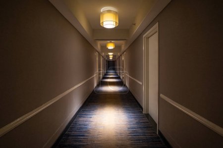 Téléchargez les photos : Long couloir sombre à l'intérieur hôtel. Vue en perspective. - en image libre de droit