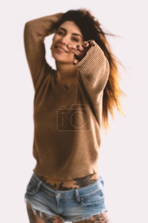 Foto de Retrato de mujer sonriente con gestos de mano sobre fondo blanco de la pared. Enfoque selectivo. Imagen filtrada. - Imagen libre de derechos