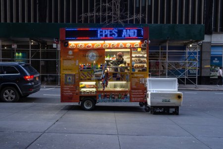 Foto de NUEVA YORK - FEBRERO, 2020: Vendedor de comida en Manhattan. La cultura gastronómica de la ciudad de Nueva York está influenciada por la historia de los inmigrantes. Hay alrededor de 4.000 vendedores de alimentos móviles con licencia de la ciudad. - Imagen libre de derechos