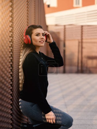 Photo for Happy young beautiful blond woman relaxing listening to music with earphones in the city. Lifestyle concept of youth, fun, enjoy life. - Royalty Free Image