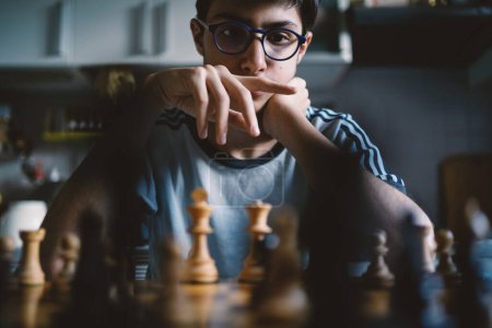 Foto de Adolescente jugando ajedrez en casa. Imagen de estilo de vida real. - Imagen libre de derechos