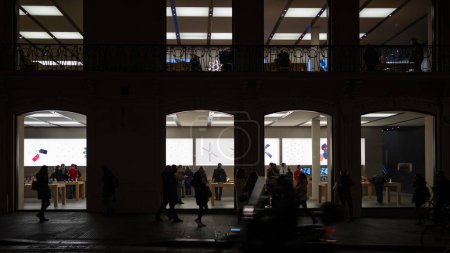 Foto de BOLOGNA, ITALIA - DICIEMBRE DE 2019: Ventanas de Apple Store por la noche. Apple Inc. es una multinacional estadounidense de tecnología con sede en Cupertino, California.. - Imagen libre de derechos