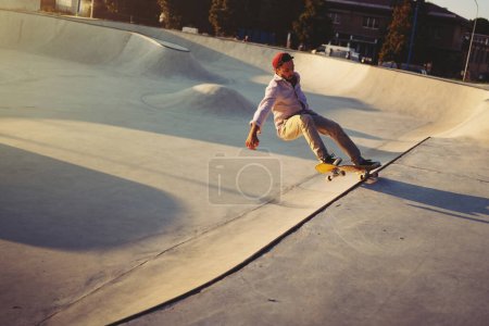 Foto de Skateboarder retrato deslizándose en el parque de skate. Luz del atardecer, estilo de vida. - Imagen libre de derechos