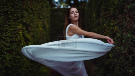 Foto de Joven hermosa bailarina bailando al aire libre con vestido largo blanco en un parque. Proyecto Bailarina. Concéntrate en el velo. - Imagen libre de derechos