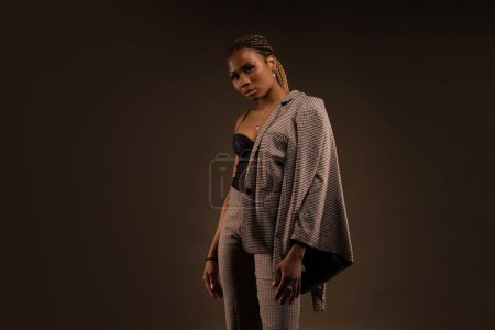 Photo for Confident elegant African black woman studio portrait against brown background. - Royalty Free Image