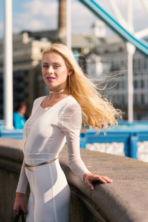 Foto de Sexy retrato de mujer rubia con elegante vestido blanco en Londres. Imagen de estilo de vida real. - Imagen libre de derechos