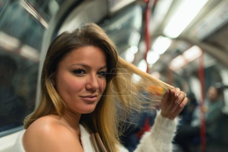 Photo for Young woman smiling portrait inside underground wagon in London. Life style real image. Shallow depth of field. - Royalty Free Image