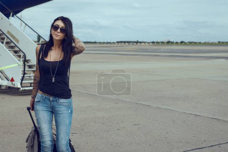 Téléchargez les photos : Jeune femme brune à l'aéroport avec avion en arrière-plan
. - en image libre de droit