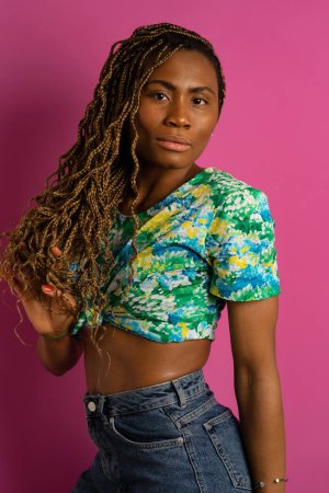 Téléchargez les photos : Belle jeune femme africaine avec tresses studio mode gros plan portrait sur fond rose. - en image libre de droit