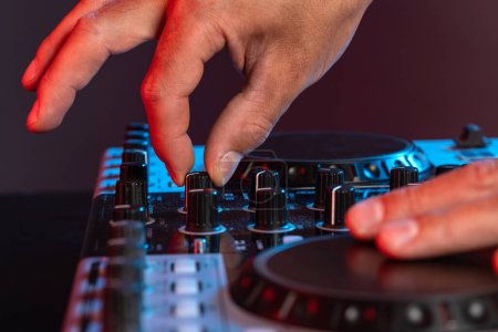 Téléchargez les photos : Mains détail de jeune homme travaillant comme DJ avec mélangeur. Profondeur de champ faible. - en image libre de droit