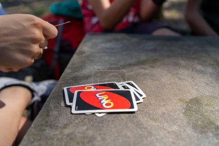 Photo for BOLOGNA, ITALY - JUNE, 2021: Playing Uno Cards on table with friends. - Royalty Free Image