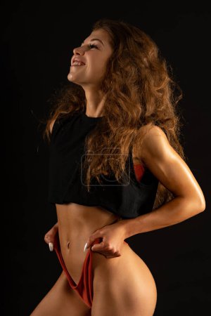 Foto de Joven mujer deportiva feliz estudio retrato sobre fondo negro. - Imagen libre de derechos