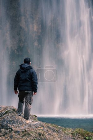 Foto de Hombre mirando cascada dentro del Parque Nacional de los Lagos Plitvice. Croacia. Europa. Concepto de exploración de naturaleza salvaje. - Imagen libre de derechos