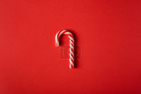 Téléchargez les photos : Canne à bonbons de Noël sur fond rouge - en image libre de droit