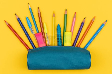 Téléchargez les photos : Vue du dessus de la trousse à crayons avec fournitures scolaires sur fond jaune. Concept de retour à l'école - en image libre de droit